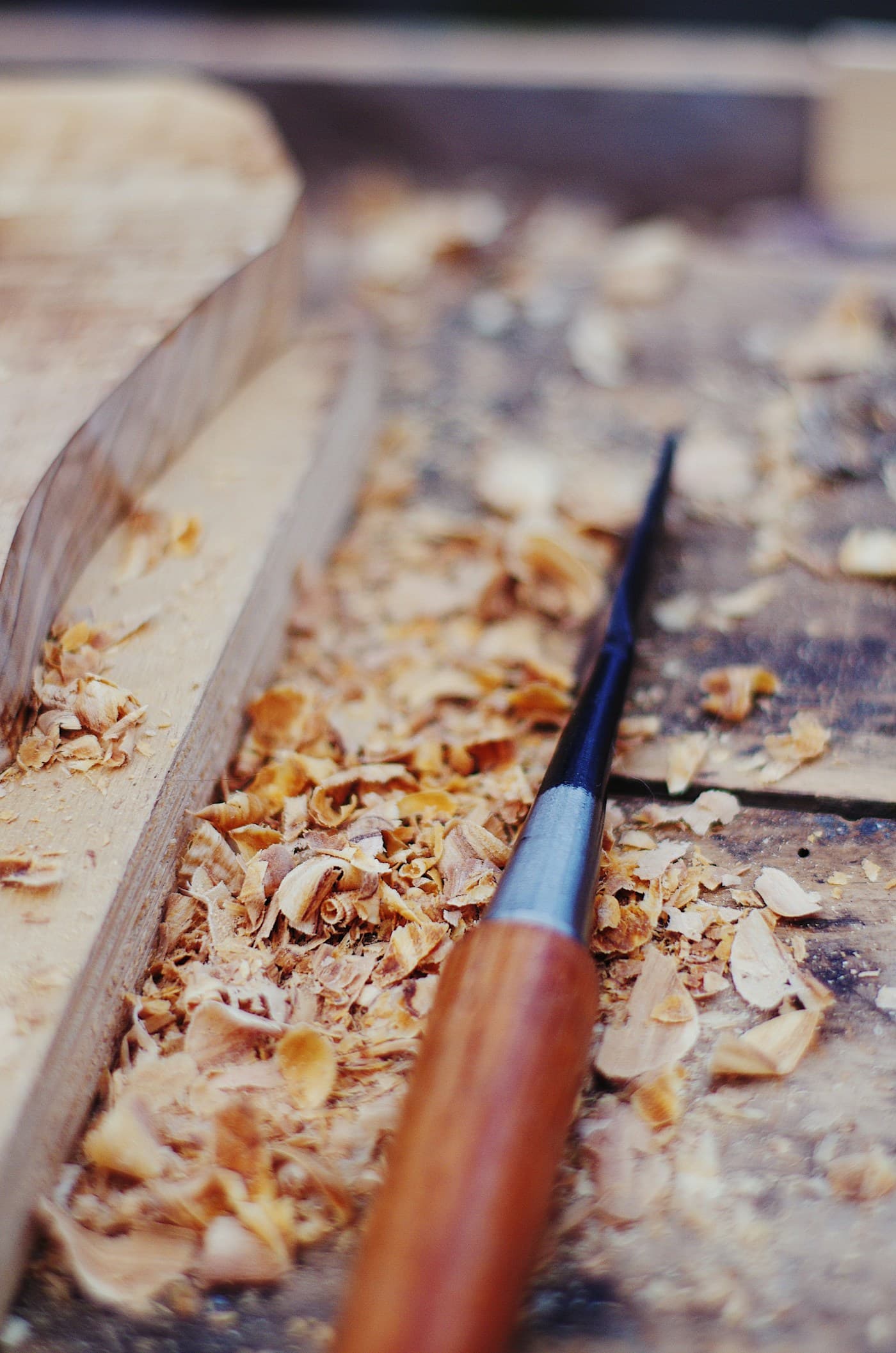 Wood chisel peeling shavings along the natural grain